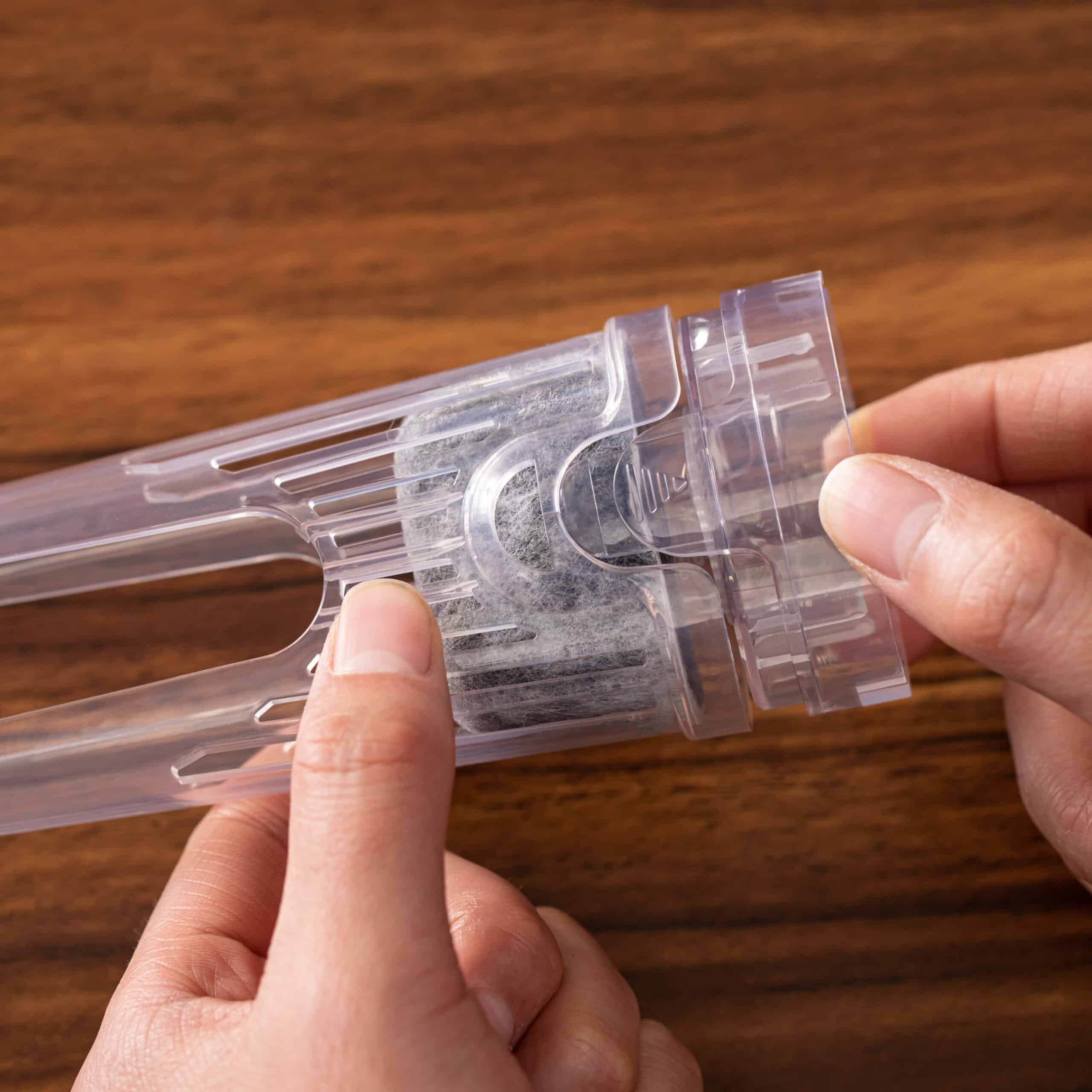 Hands replacing a water filter for Ninja DualBrew Coffee Maker