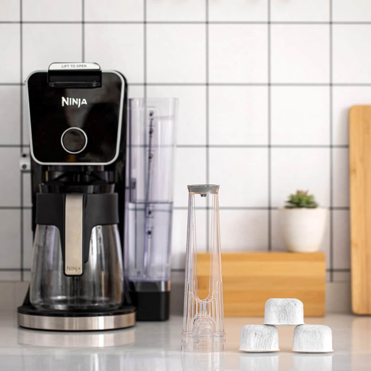 Ninja DualBrew Coffee Maker with water filter components on a kitchen counter.