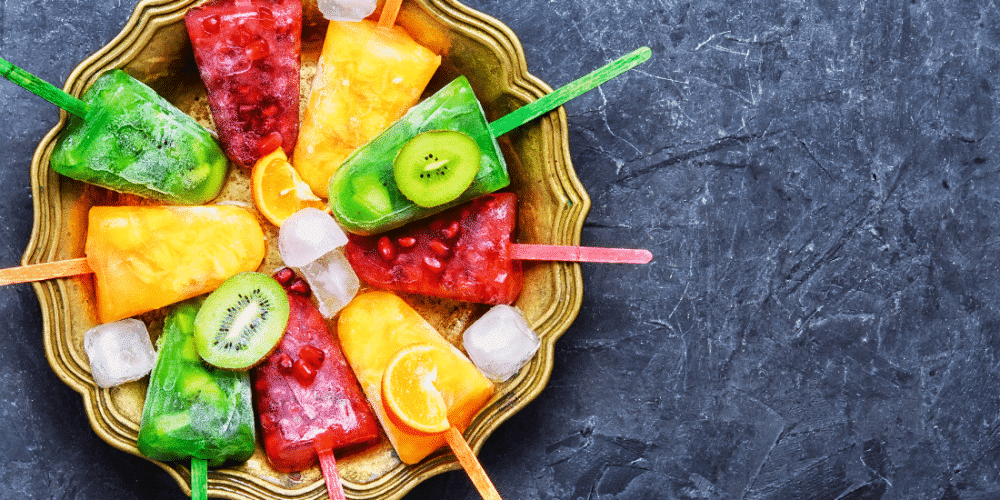 Colorful fruit popsicles in a gold tray with ice cubes. Perfect for hexagon ice tray use.