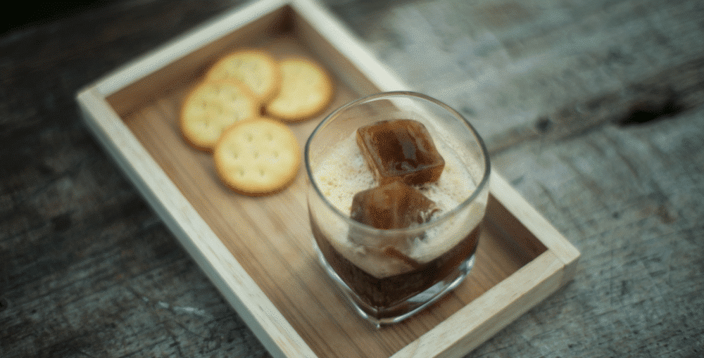 Iced coffee with coffee ice cubes and crackers on a wooden tray. BPA free ice cube trays shown.