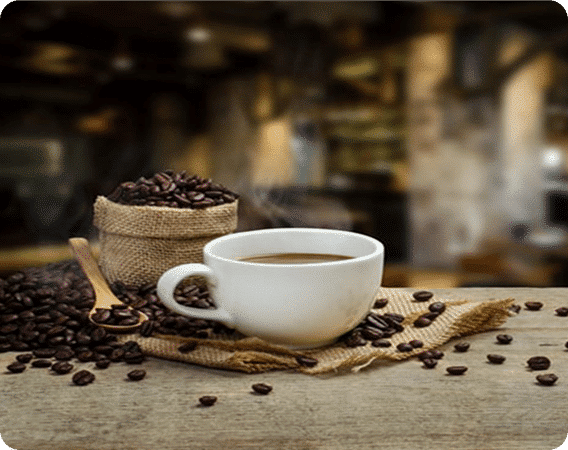 Coffee cup with beans and reusable K-Cups on a burlap sack, perfect for home brewing.