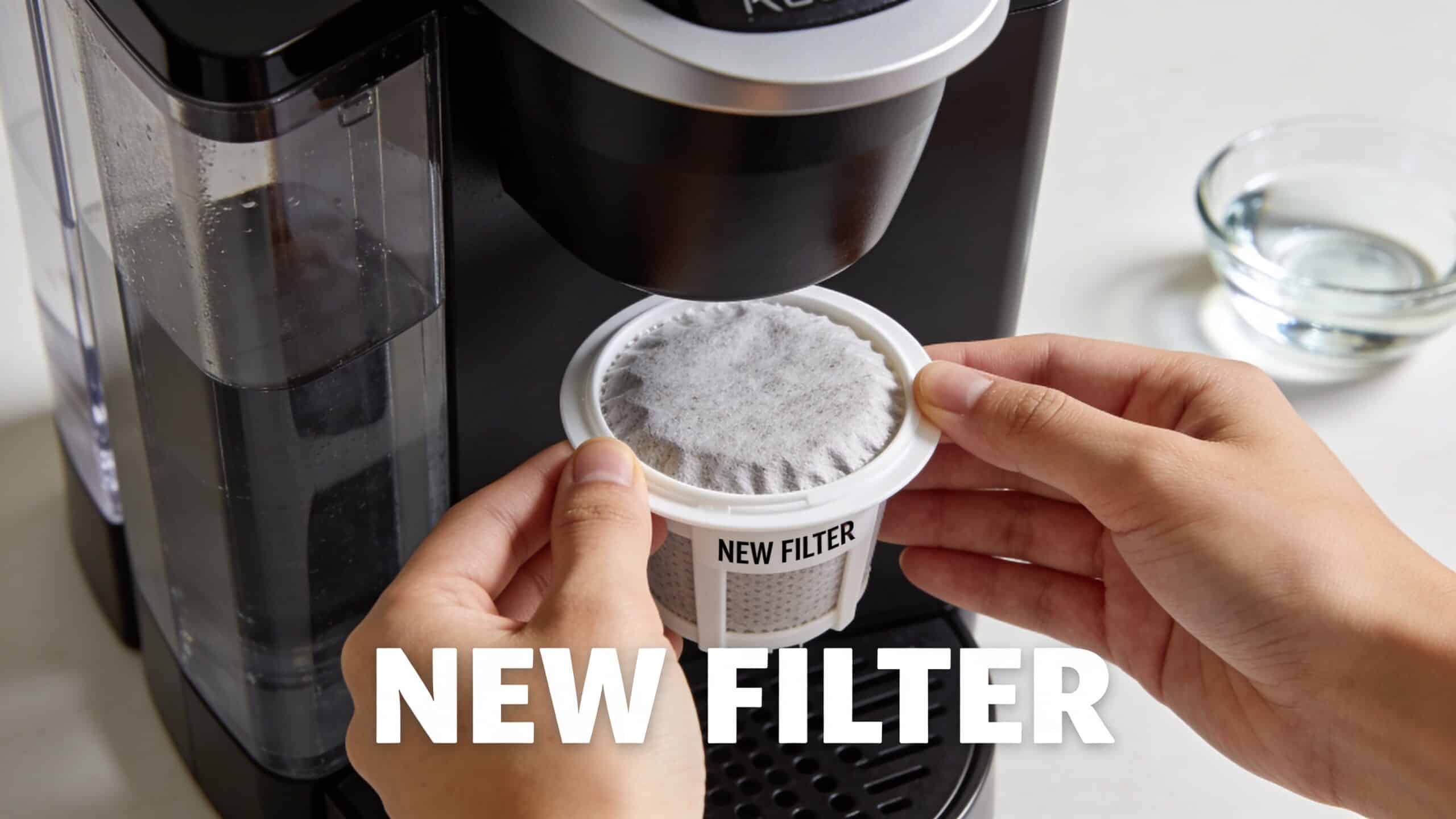 A pair of hands placing a fresh disposable Keurig coffee machine water filter into its holder.