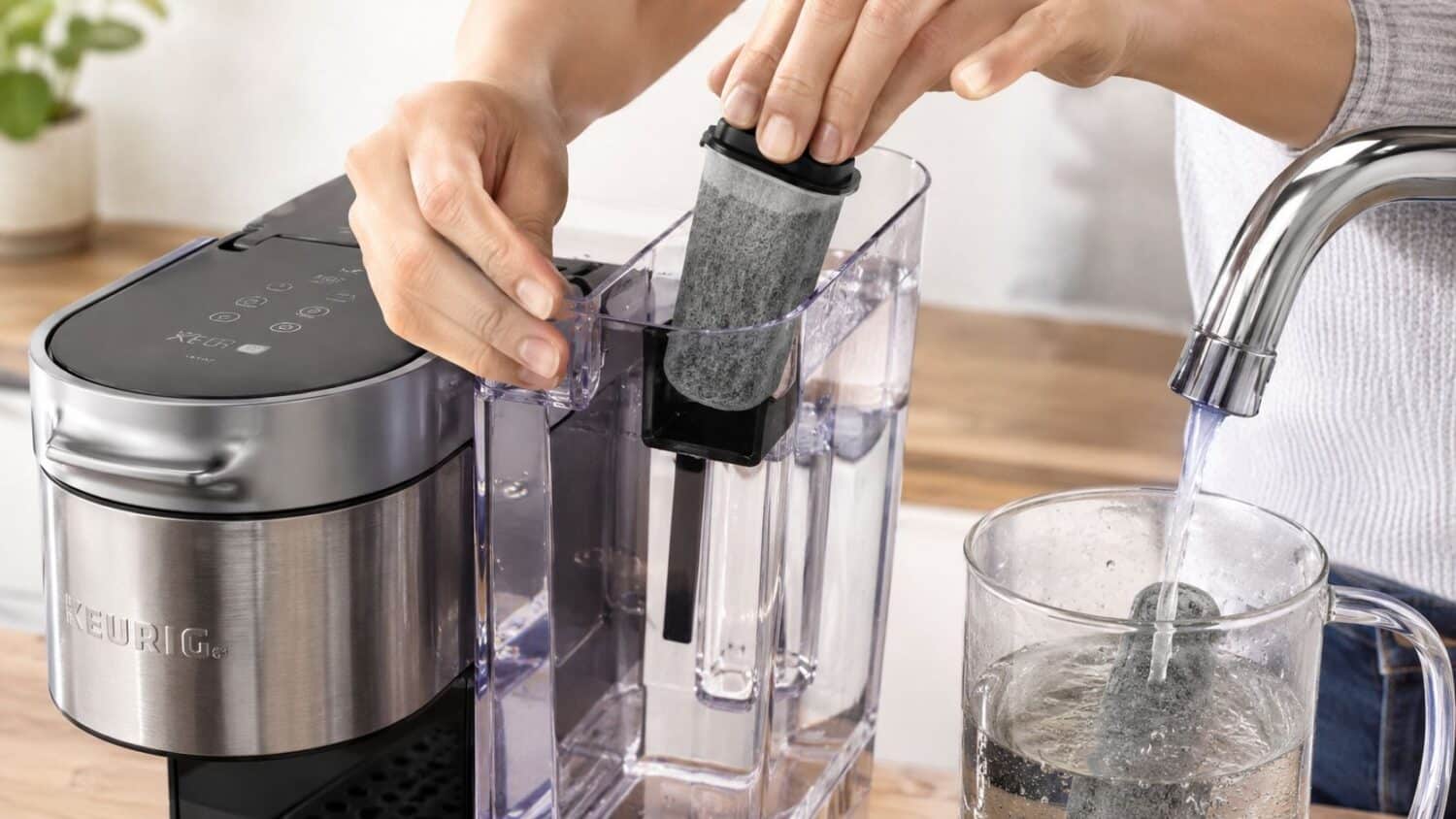 Person inserting Keurig water filter into reservoir while filling pitcher